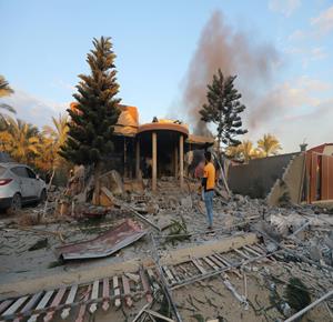 Palestinians inspecting destruction of a house after it was bombed by Israeli airstrikes in Gaza's Deir el-Balah.