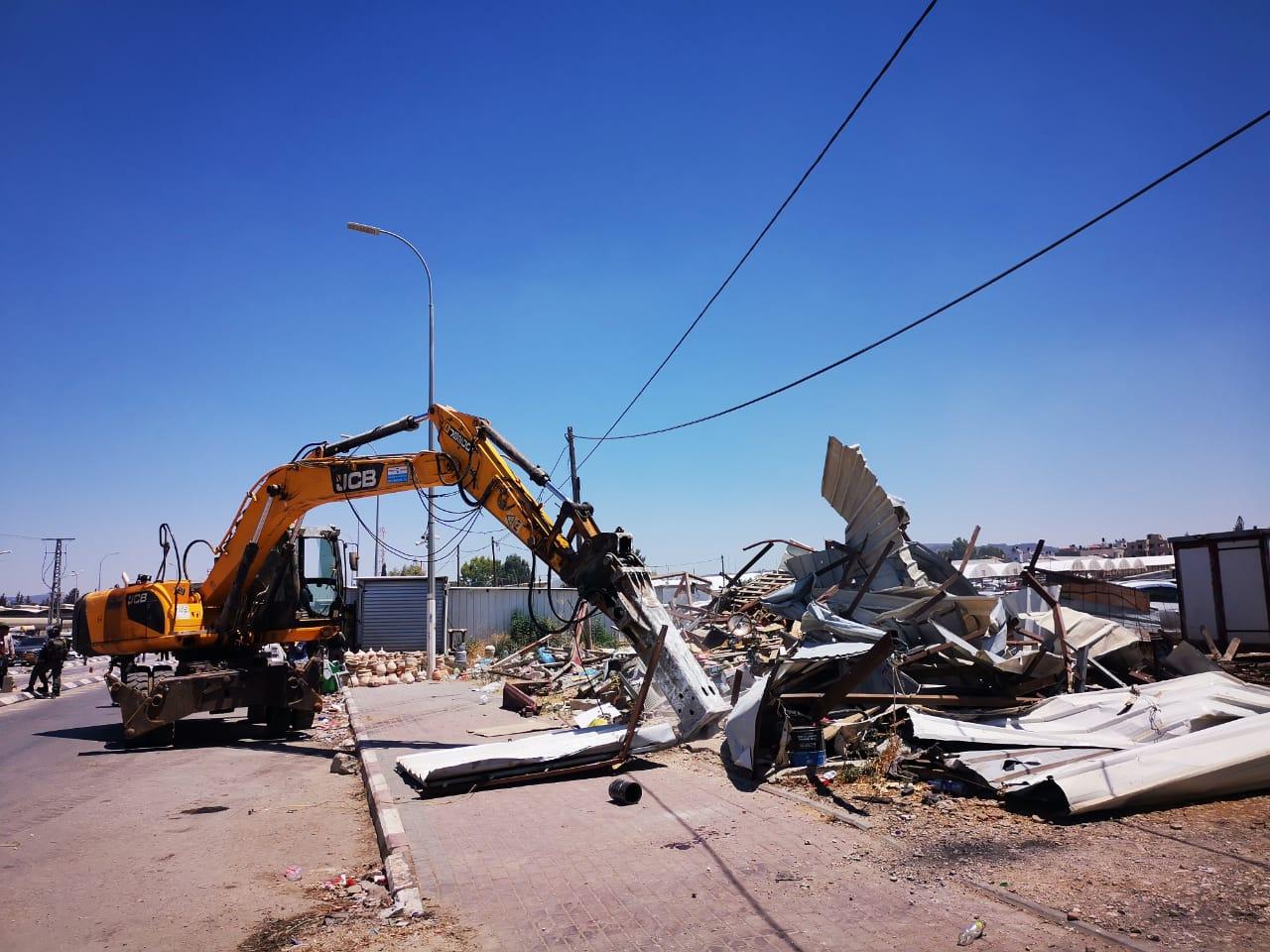Israeli army bulldozers tear down commercial structures near a checkpoint in Jenin