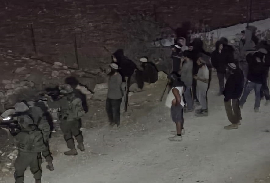 Colonists, under the protection Israeli occupation forces, during their attack on Al-Mughayyir village. 