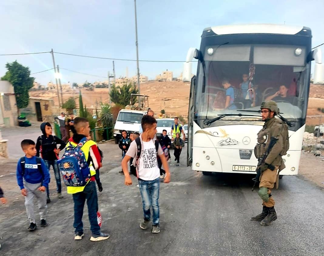 Israeli soldiers obstructing arrival of students and teachers to their schools east of Yatta.