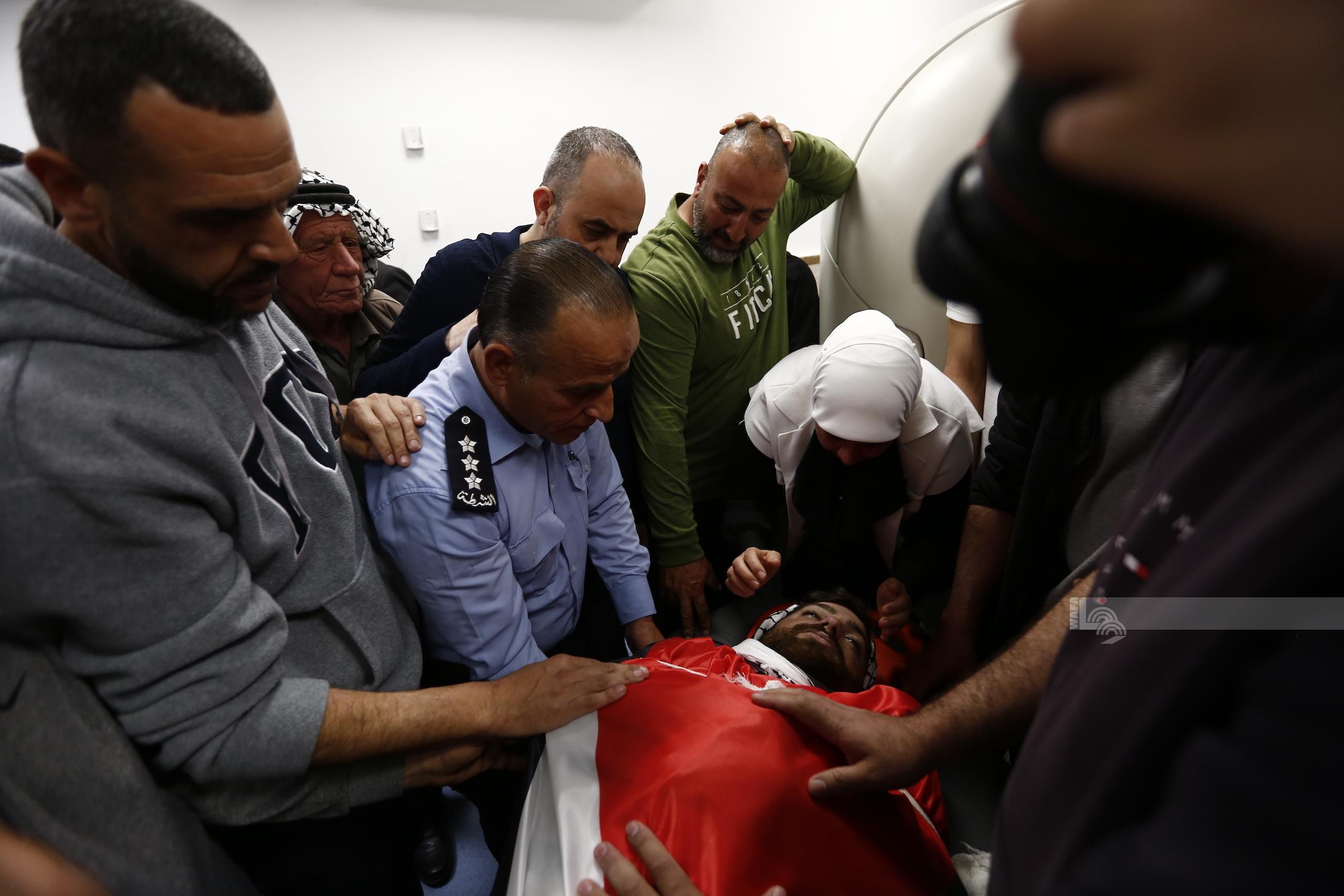 Mourners bidding farewell to the slain young man Odeh Atef Awawdeh at Palestine Medical Complex in Ramallah. (WAFA Image)