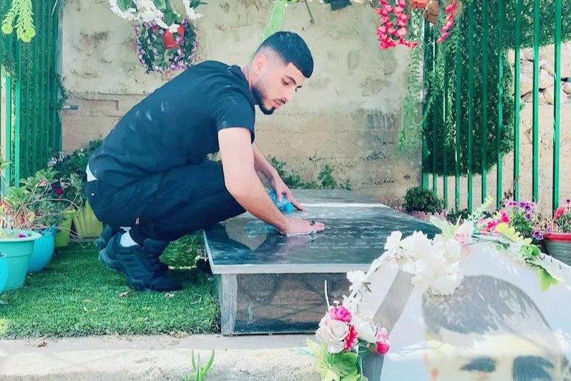 Photo of slain Wadi’ Samamrah near the grave of his slain brother Sanad, who was killed in January 2023.