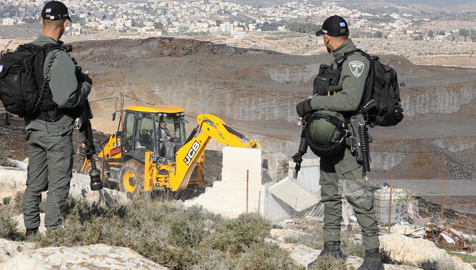 Israeli occupation forces demolish an agricultural structure, raze land, uproot olive trees south of Hebron